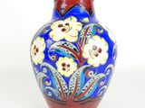 a blue vase with yellow flowers on it on a white background