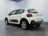 the rear of a white car is parked in a room