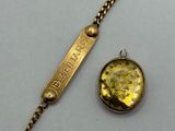 a close up of a gold bracelet with a coin on it