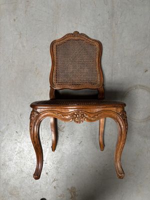 une chaise en bois posée sur une autre chaise, accrochée au mur