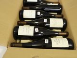 several bottles of wine are in a cardboard box on a table