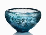 a blue glass bowl that is sitting on a table
