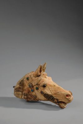 une image représentant une tête de cheval en bois sur fond gris