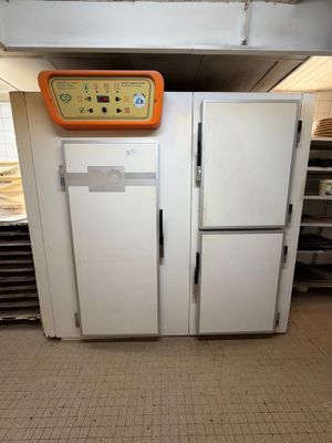 deux réfrigérateurs dans une cuisine, surmontés d'une horloge