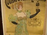 une vieille affiche représentant une femme tenant une bouteille de cognac