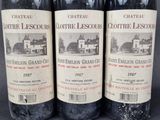 three bottles of red wine sitting on top of a table