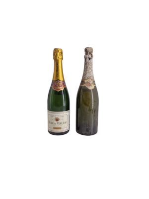 two bottles of champagne sitting next to each other on a white surface