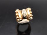 a close up of a gold ring with diamonds on a black surface