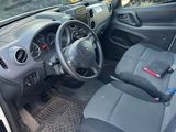 the interior of a car with the door open and a steering wheel in the passenger seat