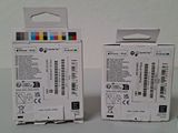 two boxes with different colored ink pens in them sitting on a table