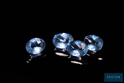 trois pierres précieuses de topaze bleue sur fond noir