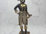 statue of a man dressed in a pirate costume holding a sword