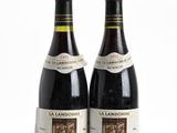 two bottles of wine sitting next to each other on a white surface