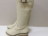 pair of white leather boots with buckles on a white surface