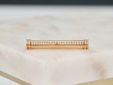 un gros plan d'une bague en lingot d'or posée sur une table en marbre