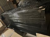 un gros tas de plastique noir emballé dans un entrepôt
