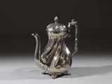 une théière ancienne en argent, dotée d'une anse, sur un fond blanc