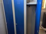 deux casiers bleus dans une salle de bains, à côté des toilettes