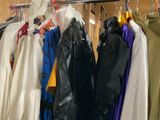 many coats hanging on a rack in a room