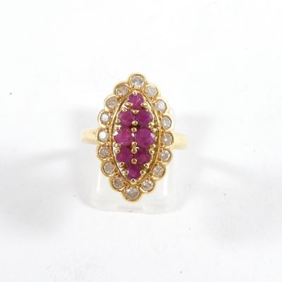 un gros plan d'une bague en or sertie d'un rubis et de diamants