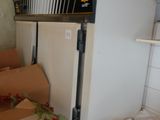 a refrigerator and boxes in a room with a lot of boxes on the floor