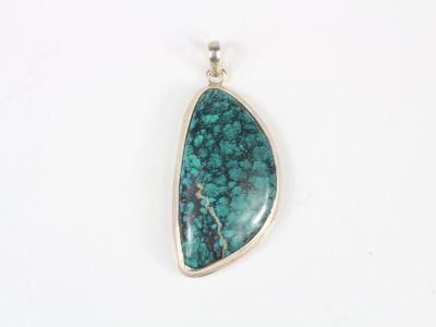 a pendant with a green stone in the middle