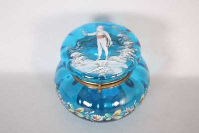 une boîte en verre bleue sur laquelle est posée une figurine
