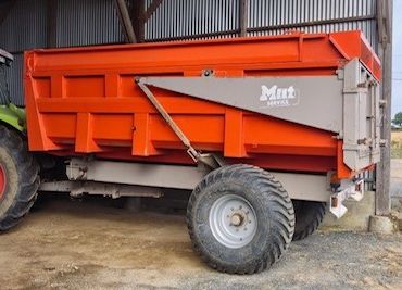 a tractor that is parked next to a dump truck