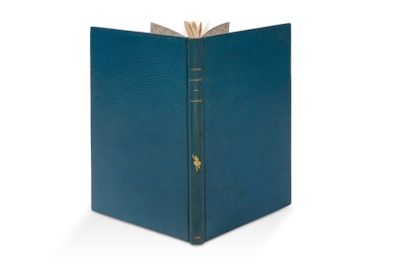 un livre bleu posé sur une surface blanche