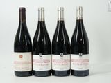 quatre bouteilles de vin sont alignées sur une surface blanche