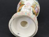 a white vase with a painting on it on a black surface