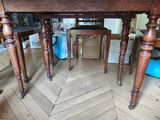 a wooden table with two chairs underneath it on a hard wood floor