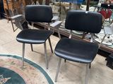 three black chairs sitting in a room with a rug on the floor
