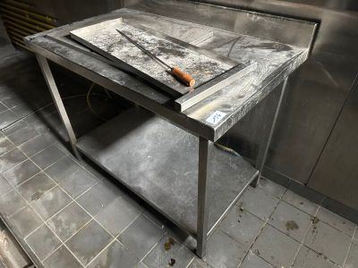 une table sur laquelle est posé un couteau, dans une cuisine