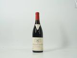 une bouteille de vin rouge posée sur une table blanche