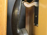 a black phone that is on the wall next to a door