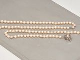 un gros plan sur un collier de perles blanches orné d'une étoile