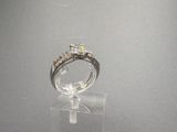 une photo d'une bague en diamant posée sur un socle transparent