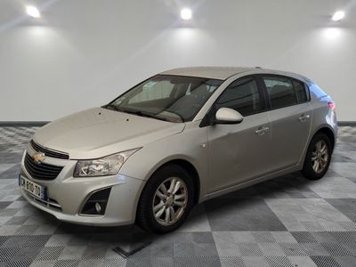 La Chevrolet Cruz est garée dans une pièce dont le sol est en damier.