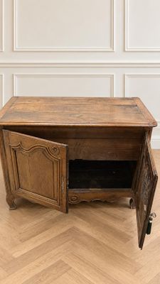 une petite table en bois dont la porte est ouverte et repose à même le sol