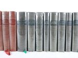 several books are lined up in a row on a white surface