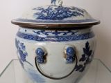 a blue and white bowl with a lid on a glass shelf