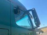 a large green truck with a mirror on it ' s side