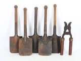several old tools are lined up in a row on a white surface