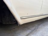 a close up of a white car with a flat tire
