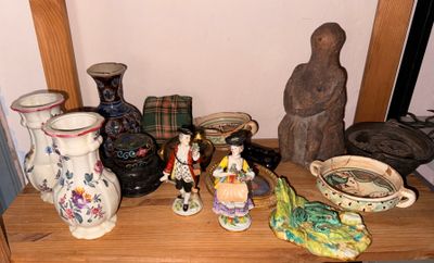 de nombreux vases de toutes sortes posés sur une étagère en bois dans une pièce