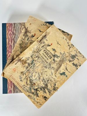 three books are stacked on top of each other on a white surface