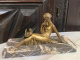une statue représentant une femme assise sur un bloc de marbre