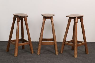 trois tabourets en bois placés les uns à côté des autres dans une pièce