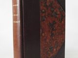 a brown and black book sitting on top of a white table